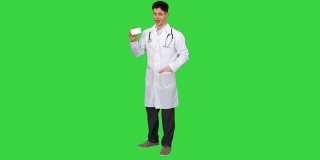 医生拿着一盒药丸宣传他们，并在绿色屏幕上跳舞，色度钥匙