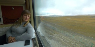 近距离观察:女性旅行者在火车上观察喜马拉雅景观。