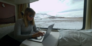 特写:女旅行者在坐火车旅行时写她的旅行博客。