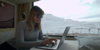 特写:一名女子在穿越西藏的火车上用笔记本电脑回复电子邮件
