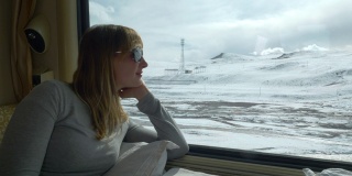 近距离观察:一名年轻女子在火车上观察雪景喜马拉雅。