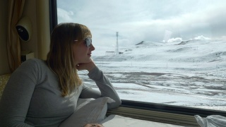 近距离观察:一名年轻女子在火车上观察雪景喜马拉雅。视频素材模板下载