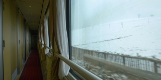 近距离观察:一个不知名的游客在火车上拍摄雪山西藏的照片。
