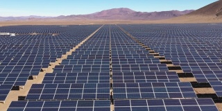 航拍数以百计的太阳能模块或电池板沿着智利阿塔卡马沙漠干燥干旱的土地。从无人机的视角看沙漠中部巨大的光伏电站