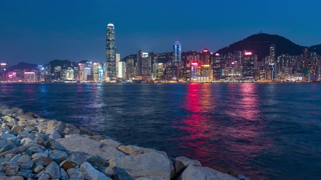 4K:时光流逝由昼到夜，照亮维多利亚湾和香港中心的建筑基础设施-维多利亚港与现代化的商业建筑外部地区城市
