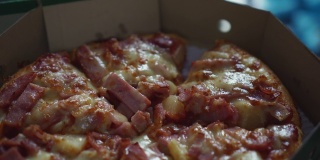 纸盒子上的披萨火腿奶酪特写。