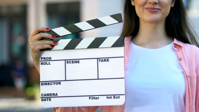 手持拍板的年轻女子，电影助理导演，视频制作
