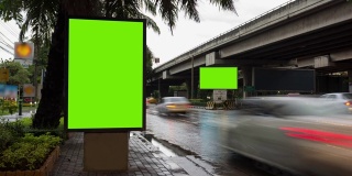 时间流逝，交通长曝光在道路与广告牌绿色屏幕用于广告的街道标志在城市。