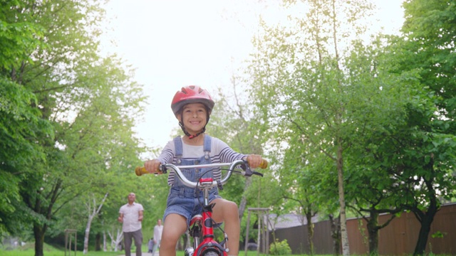 父亲放开了他的儿子，男孩独自骑着自行车沿街而行