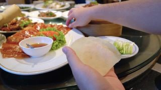亚洲人在吃北京烤鸭(中国菜)。视频素材模板下载