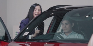 亚洲女销售员介绍客户试驾的4K慢镜头