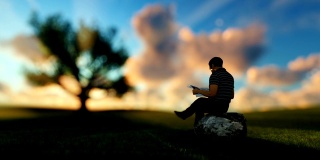 一个人在绿色草地上看报纸，享受一段时间的日出，缩小