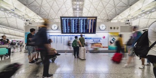 4K超高清延时拍摄，拥挤的人群在香港机场候机楼检查到离港板和行走。航空运输，出国旅行，或通勤的生活方式概念。相机