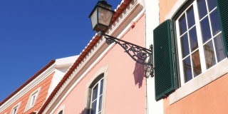 在葡萄牙卡斯凯斯，在明亮的蓝色天空的映衬下，仰望色彩斑斓、充满活力的白色建筑