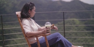 年轻女子坐在摇椅上喝茶。