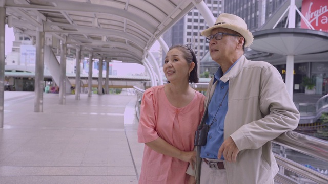 亚洲老年夫妇拿着地图搜索泰国的目的地街道，幸福意味着一切作为灵感的概念，退休年龄老年人用自己的储蓄旅行，旅行者和生活方式的老，幸福意味着一切