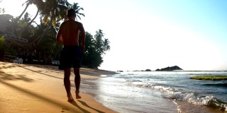 穿着蓝色短裤的人在潮湿的沙滩上奔跑，留下脚印