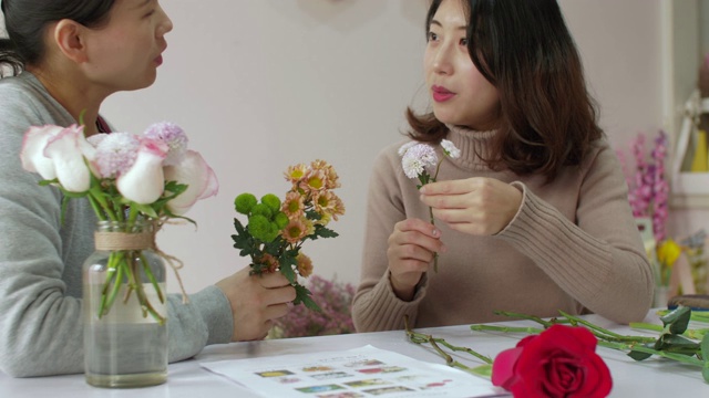 女孩花商正在训练她的朋友如何制作漂亮的花束