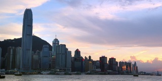 九龙湾日落与渡轮在香港海港，城市景观背景