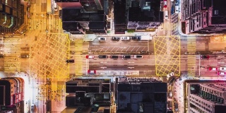 4K超高清延时拍摄香港市中心地区夜间车辆行驶和行人过马路，无人机俯视图。通勤者，亚洲城市生活，或公共交通概念，缩小
