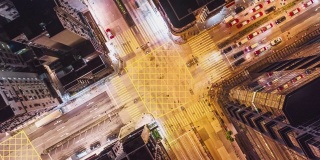 4K超高清Hyperlapse延时拍摄香港市中心夜间的车辆交通和行人过马路。无人机俯视图，向上飞行。通勤，亚洲城市生活或公共交通理念
