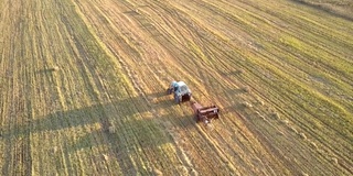 上视图拖拉机在收获的土地上拉捆收集器