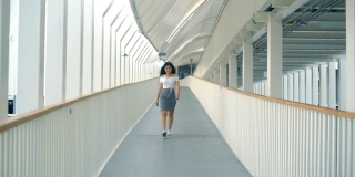 快乐年轻的亚洲女人正走在天桥上