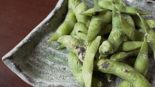 煮熟的绿色有机毛豆与盐翻，日本食物视频素材模板下载