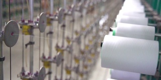 纺织厂工业整经整经机上的白色线轴筒子线锥