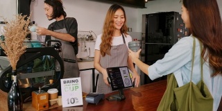 年轻的亚洲女咖啡师向亚洲顾客解释零浪费折扣促销，在咖啡馆的柜台吧台买咖啡时自己带咖啡杯，慢镜头