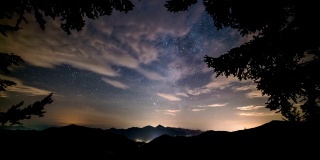 美丽的森林景观星空与银河和云移动阿尔卑斯山山脉自然时光流逝