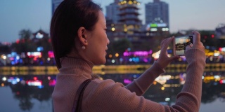 美丽的中国游客在成都九烟桥边的霓虹灯光下欣赏风景
