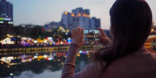 美丽的中国游客在成都九烟桥边的霓虹灯光下欣赏风景