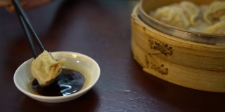 在餐厅里把饺子蘸酱油。传统的中国食物