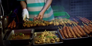 慢动作卖主烹饪台湾鸡棒。夜市街道。
