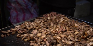 慢镜头小贩烹饪台湾猪肉在钢烤架上。夜市