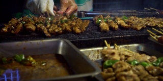 慢动作卖主烹饪台湾鸡棒。夜市街道。