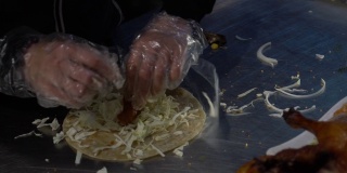 亚洲女子制作北京烤鸭的慢镜头。使玉米煎饼