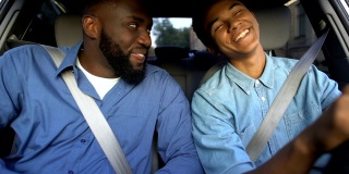 微笑的美国父亲赞扬儿子学习开车，父母帮助，家庭