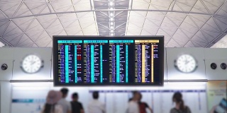游客在国际机场候机楼的航班时刻表延误