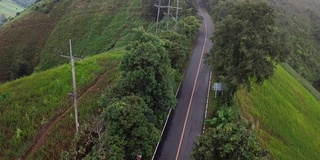 鸟瞰图，在泰国北部的森林雾中行驶的道路与一辆移动的汽车