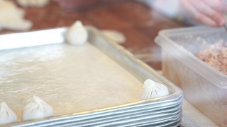 制作小笼包的步骤。它是中国最受欢迎的点心。小笼包是由面粉、小麦粉、猪肉末和水汤混合而成。视频素材模板下载