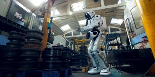 机器人在工厂里用平板电脑检查金属零件。