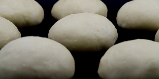 由酵母面团制成的面包在黑色背景下变大。间隔拍摄