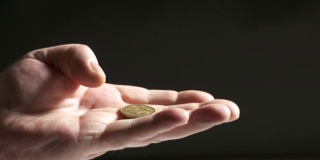 手抛硬币。近距离向空中投掷1枚乌克兰格里夫尼亚硬币。
