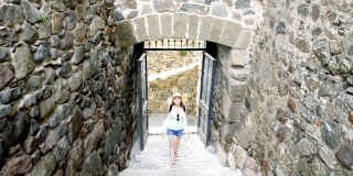 年轻女子打开铁门，走进城堡的庭院