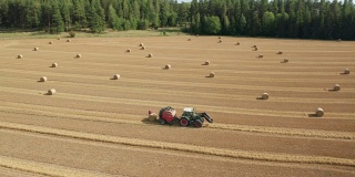 鸟瞰图的拖拉机收集干草和释放干草辊在田间