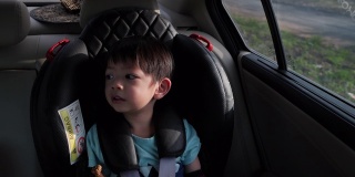 可爱的男孩坐在汽车座椅上