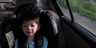 可爱的男孩坐在汽车座椅上