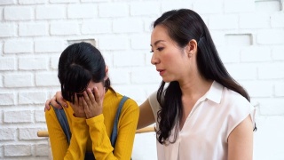 亚洲母亲安慰哭泣的十几岁的女儿在痛苦，压力，沮丧，悲伤的心态视频素材模板下载